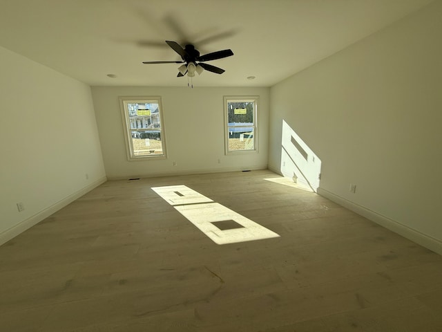 unfurnished room with light wood-type flooring, baseboards, and a ceiling fan