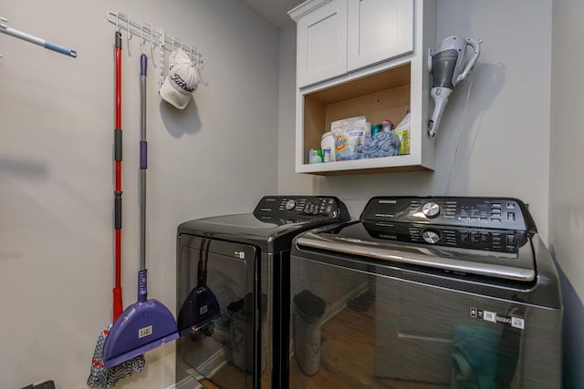 washroom with washing machine and dryer and cabinets