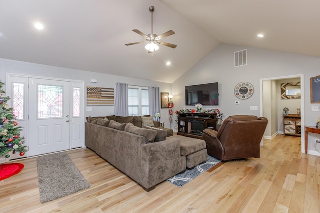 living room featuring ceiling fan, high vaulted ceiling, and light hardwood / wood-style flooring