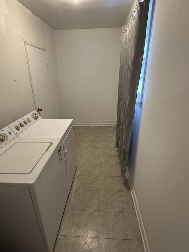 laundry area with laundry area, washing machine and clothes dryer, and baseboards