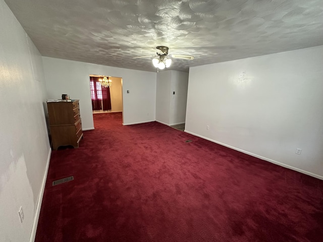 carpeted spare room featuring baseboards, visible vents, and a textured ceiling