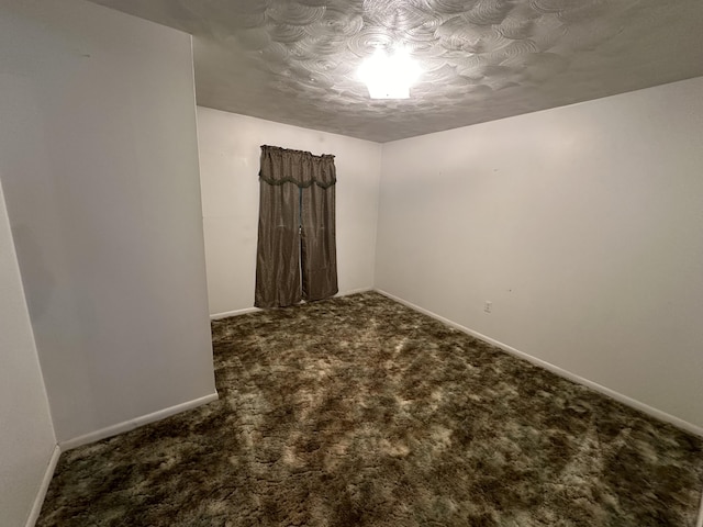 carpeted spare room featuring baseboards