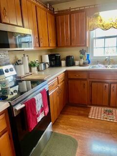 kitchen with sink, appliances with stainless steel finishes, and light hardwood / wood-style flooring