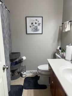 bathroom featuring tile patterned flooring, curtained shower, vanity, and toilet