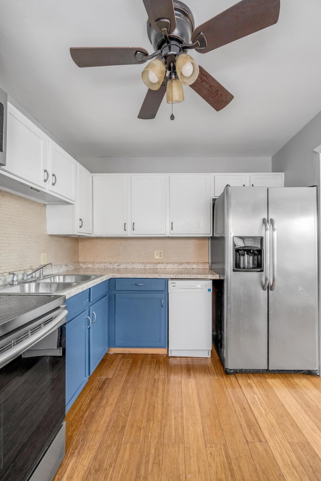 kitchen featuring blue cabinetry, appliances with stainless steel finishes, white cabinets, and light hardwood / wood-style flooring