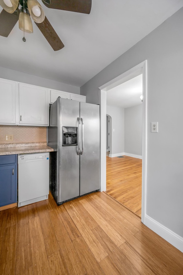 kitchen with white dishwasher, white cabinets, blue cabinets, light wood-type flooring, and stainless steel fridge with ice dispenser