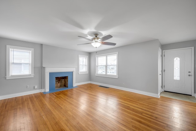 unfurnished living room featuring ceiling fan and light hardwood / wood-style flooring