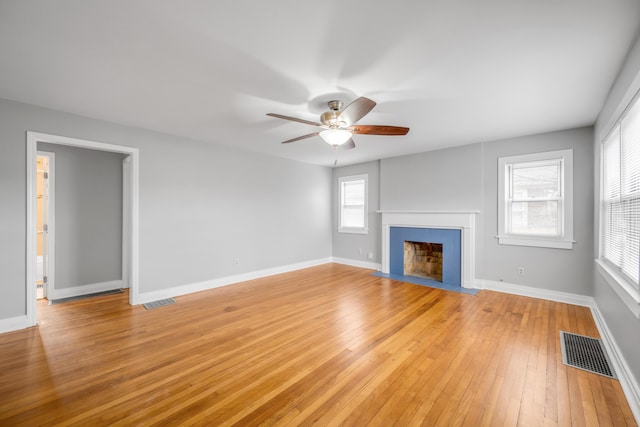 unfurnished living room with ceiling fan, a healthy amount of sunlight, and light hardwood / wood-style floors