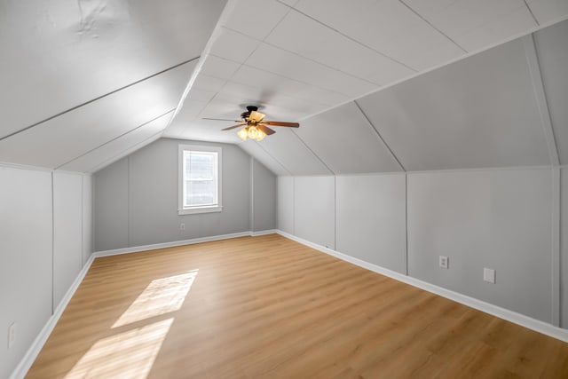 additional living space with hardwood / wood-style flooring, vaulted ceiling, and ceiling fan