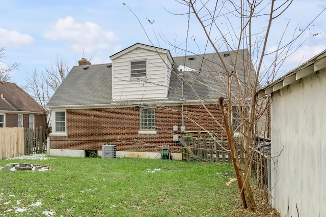 back of house featuring a yard and central air condition unit