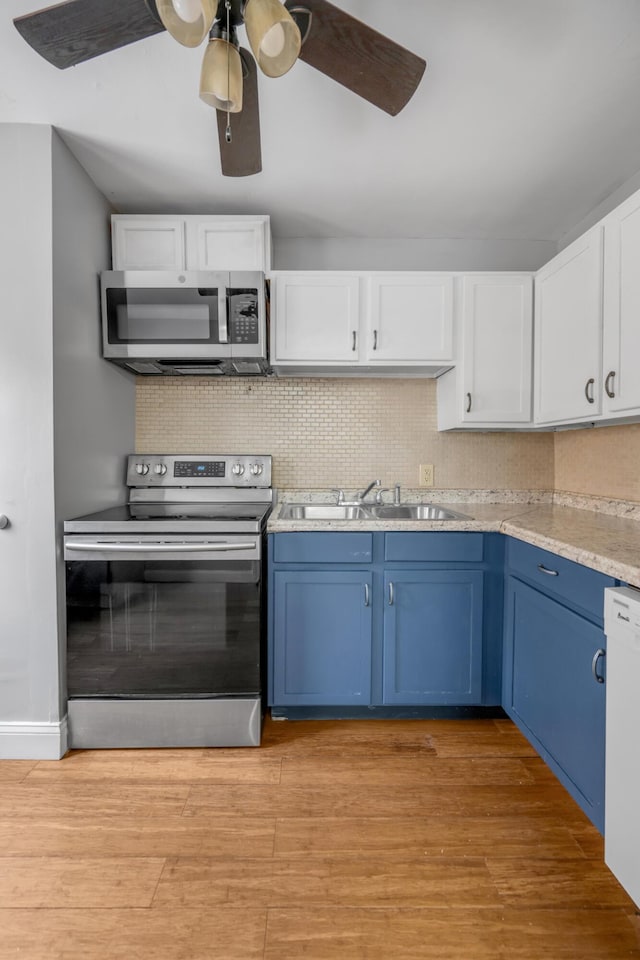 kitchen featuring blue cabinetry, white cabinetry, light hardwood / wood-style flooring, and stainless steel appliances