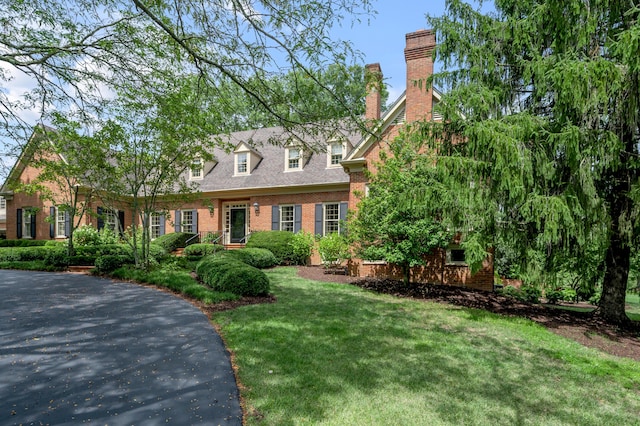 1821 Delong Rd, Lexington, KY 40515 - new england style home featuring a front yard, a chimney, and brick siding