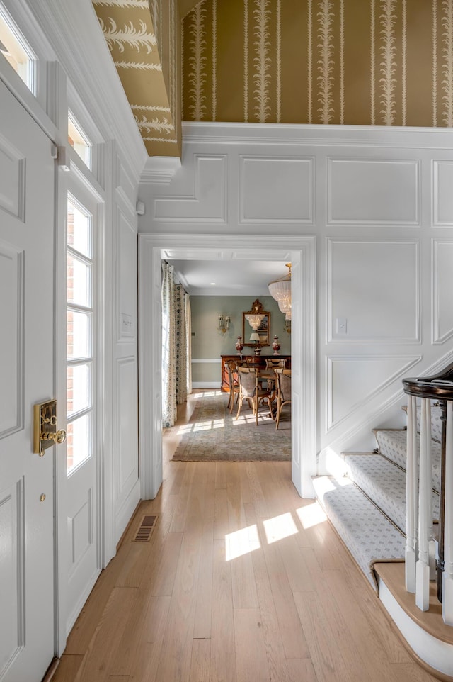1821 Delong Rd, Lexington, KY 40515 - entrance foyer featuring light wood finished floors, a decorative wall, visible vents, and stairs