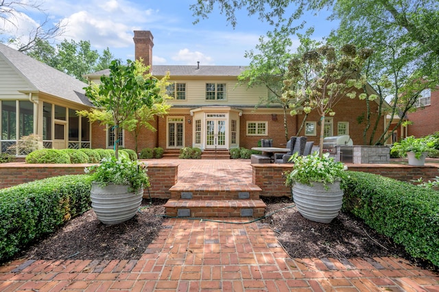 1821 Delong Rd, Lexington, KY 40515 - back of house with a chimney, brick siding, a patio area, french doors, and exterior kitchen
