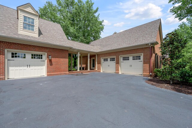 1821 Delong Rd, Lexington, KY 40515 - view of front of property with a garage, a shingled roof, aphalt driveway, and brick siding