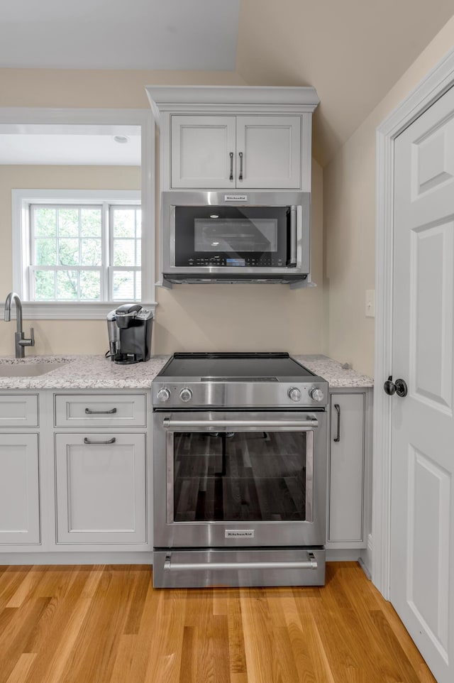 1821 Delong Rd, Lexington, KY 40515 - kitchen with light stone countertops, stainless steel appliances, light wood-style floors, and a sink