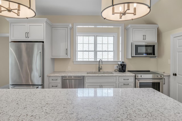 1821 Delong Rd, Lexington, KY 40515 - kitchen featuring pendant lighting, a sink, appliances with stainless steel finishes, an inviting chandelier, and light stone countertops