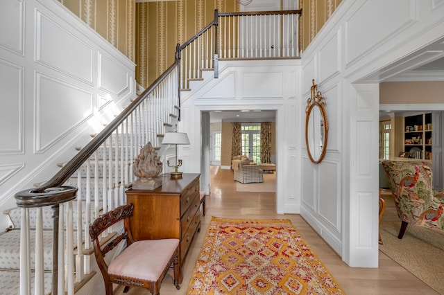 1821 Delong Rd, Lexington, KY 40515 - entrance foyer with light wood-style floors, wallpapered walls, ornamental molding, a towering ceiling, and stairs