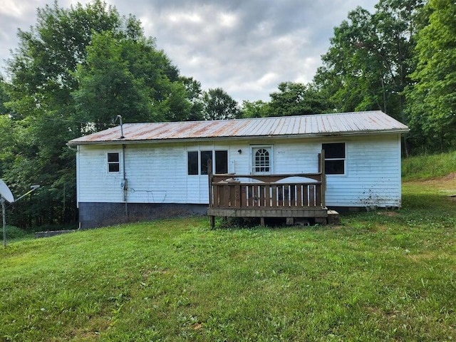 back of property featuring a yard and a wooden deck