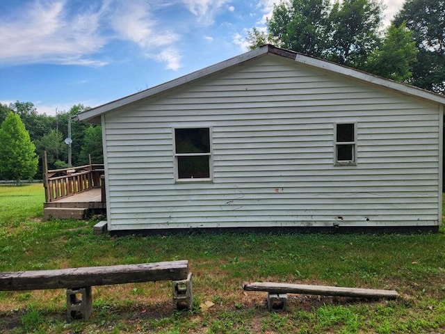 view of side of home featuring a lawn and a wooden deck