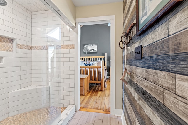 ensuite bathroom featuring wood finished floors, ensuite bath, and a tile shower