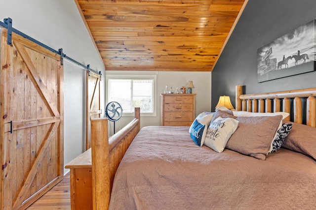 bedroom with a barn door, light wood-style flooring, wooden ceiling, and vaulted ceiling