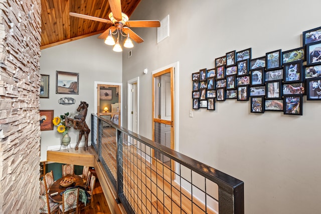 hall featuring visible vents, an upstairs landing, high vaulted ceiling, and wooden ceiling