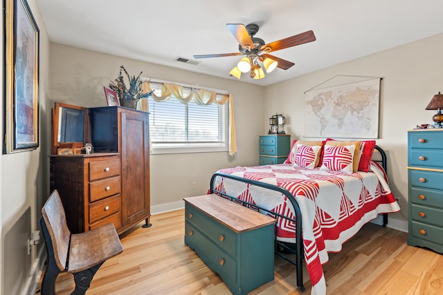 bedroom featuring visible vents, light wood-style flooring, a ceiling fan, and baseboards