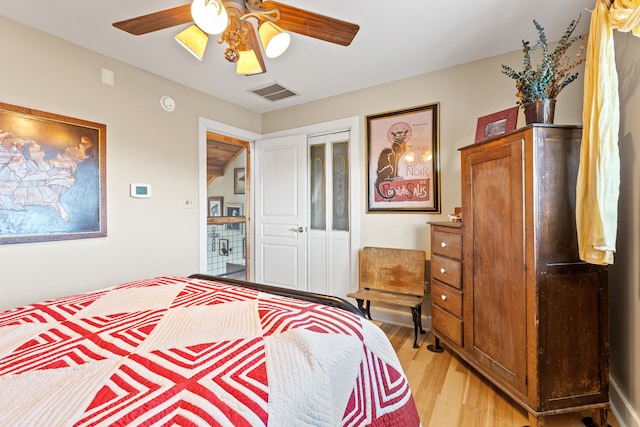 bedroom with visible vents, light wood-style floors, a closet, and ceiling fan