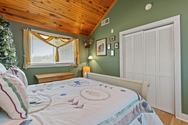 bedroom featuring visible vents, wood ceiling, lofted ceiling, wood finished floors, and a closet