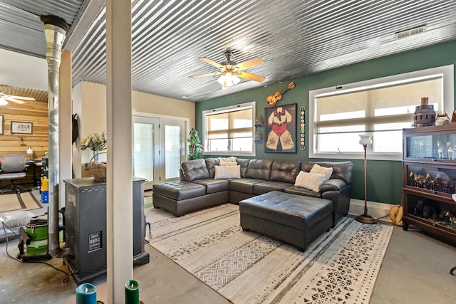 living area featuring visible vents, concrete flooring, and ceiling fan