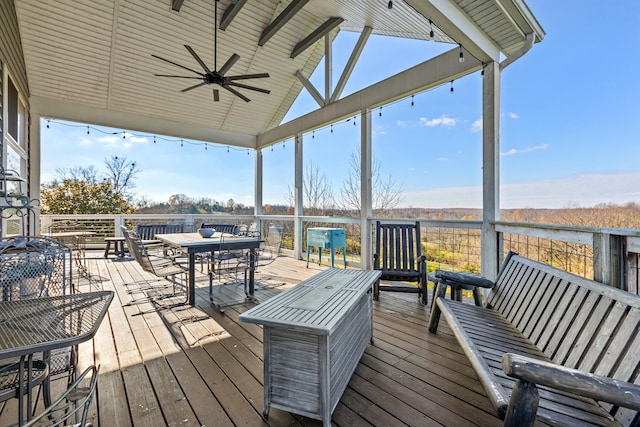 wooden terrace featuring outdoor dining area and a ceiling fan