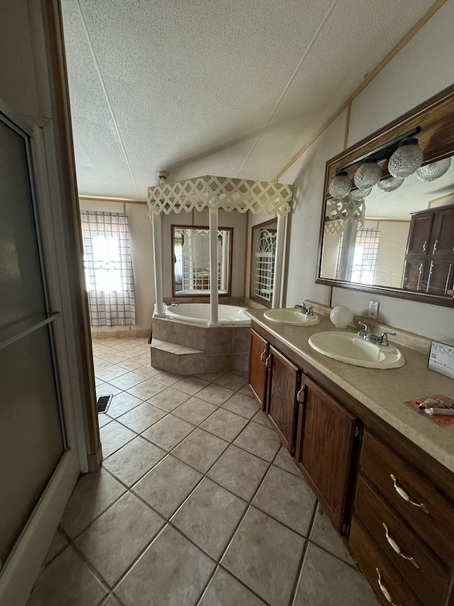 bathroom featuring tile patterned floors, a relaxing tiled tub, a textured ceiling, and vanity