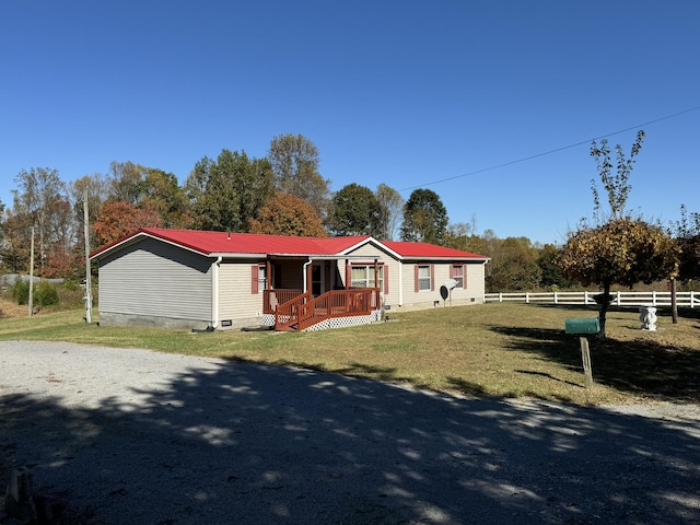 manufactured / mobile home featuring covered porch and a front yard