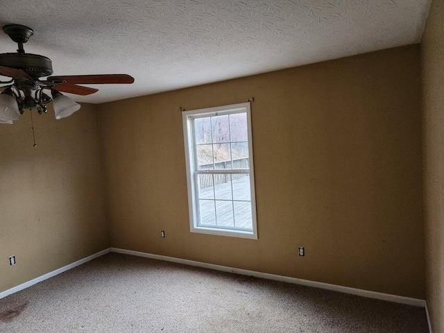 carpeted empty room with ceiling fan and a textured ceiling