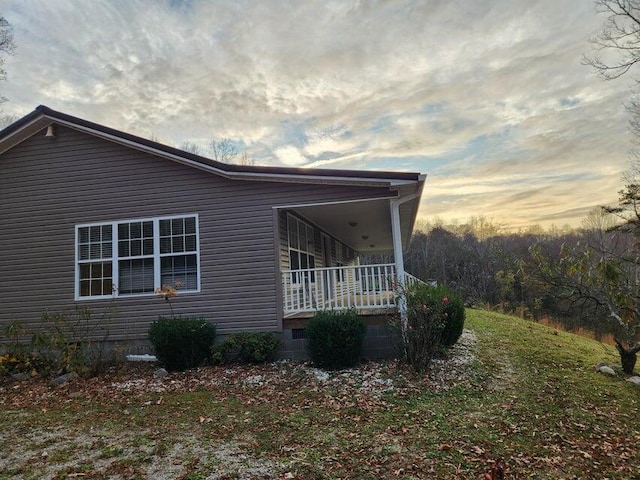 property exterior at dusk featuring a porch