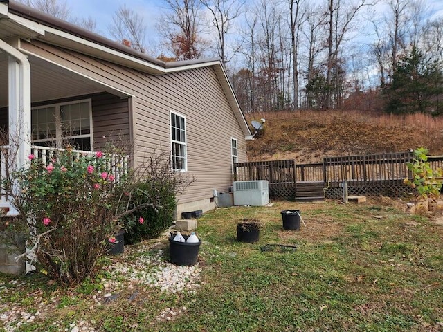 view of home's exterior with a deck, cooling unit, and a lawn