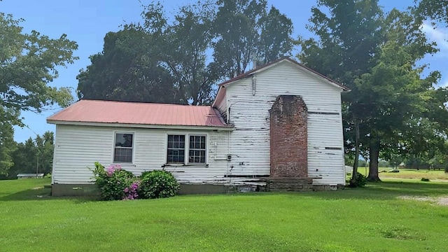 back of house with a lawn