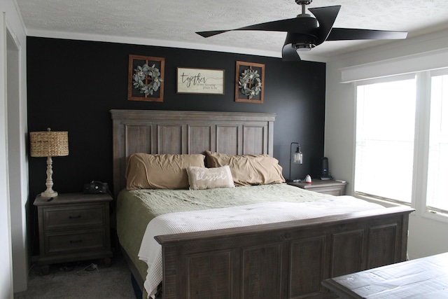 bedroom with carpet flooring, a textured ceiling, multiple windows, and ceiling fan