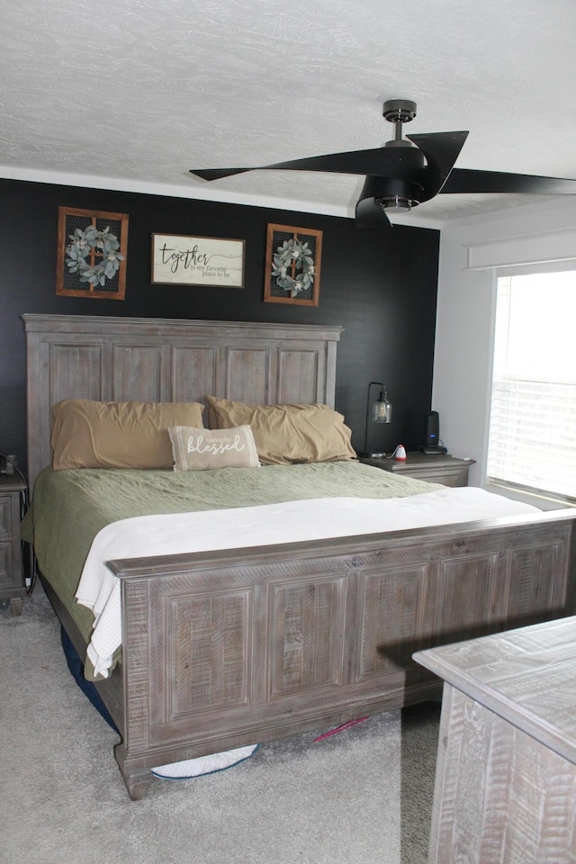 bedroom with a textured ceiling, carpet floors, and ceiling fan