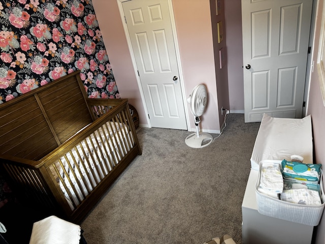 carpeted bedroom featuring a nursery area