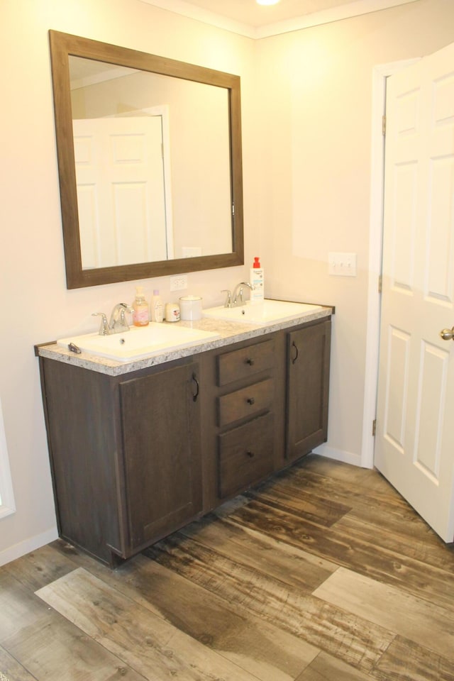 bathroom featuring hardwood / wood-style floors, vanity, and crown molding