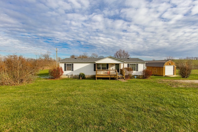 view of front of property featuring a wooden deck, a front lawn, an outdoor structure, and a garage