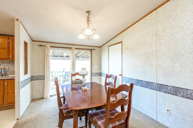 carpeted dining room featuring crown molding, lofted ceiling, a textured ceiling, and an inviting chandelier