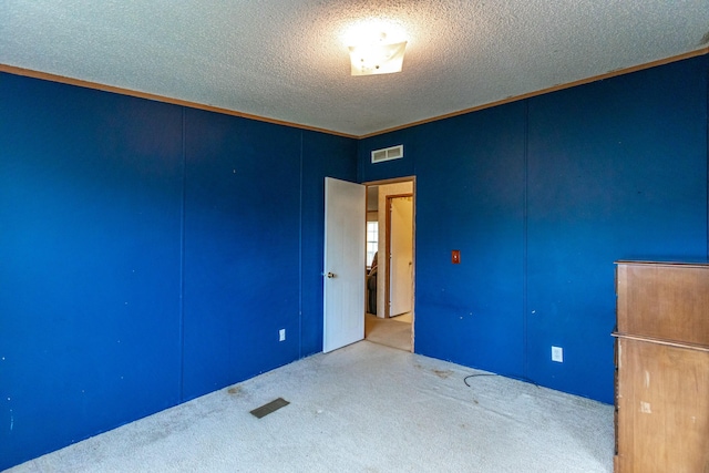 unfurnished room featuring carpet floors, a textured ceiling, and ornamental molding