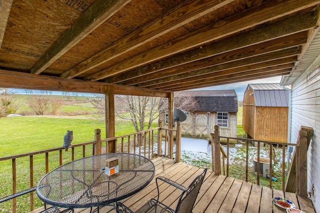 wooden terrace featuring a yard and a shed