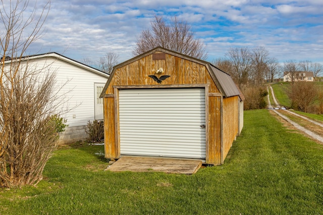 view of outbuilding with a garage and a lawn