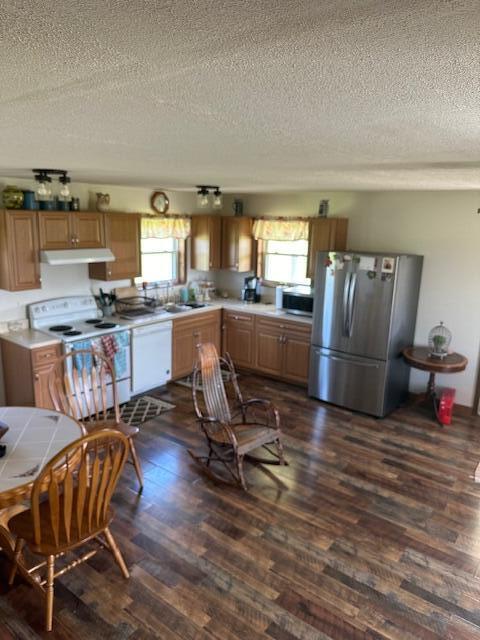 kitchen featuring dark hardwood / wood-style floors, sink, white appliances, and a textured ceiling