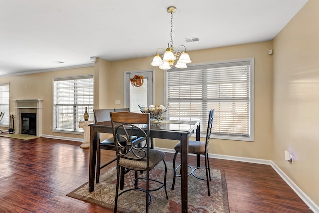 dining room with a notable chandelier, dark hardwood / wood-style floors, and ornamental molding