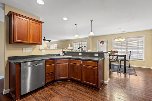 kitchen with sink, hanging light fixtures, dark hardwood / wood-style flooring, stainless steel dishwasher, and ceiling fan with notable chandelier